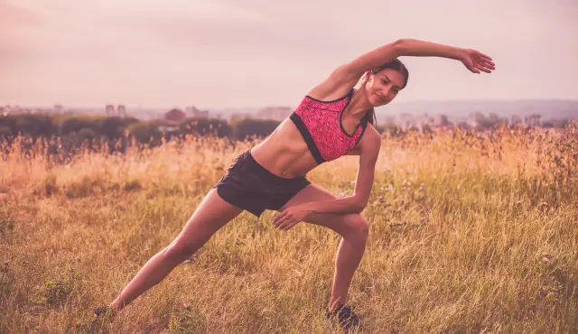 Mujer joven estirando cuerpo después de hacer ejercicio