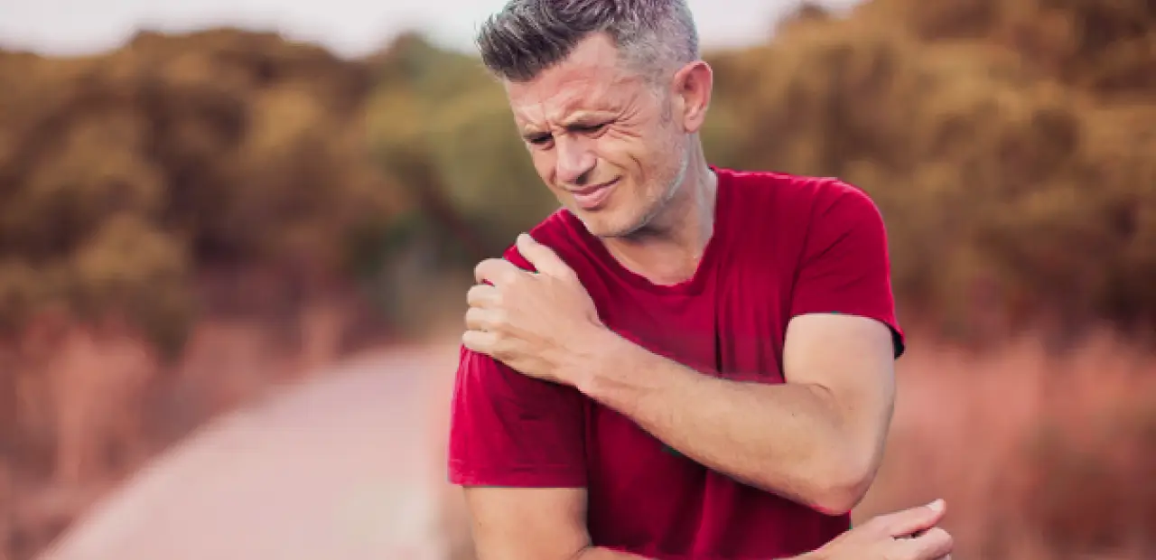 Hombre con dolor en los hombros luego de entrenar